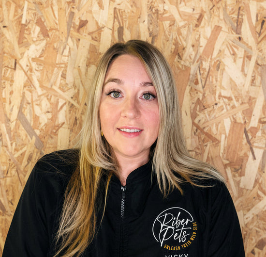 Woman wearing a black groomingjacket with 'Riber Pets' logo, featuring the name 'Vicky'.